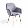 Modern velvet armchair with slim gold legs and scalloped back