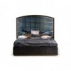 Grand designer bed with arched panels, detailed frame, and luxurious textured fabric