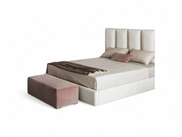 Cream upholstered bed with wide vertical panels and gold accents