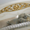 Classic ornate bed with curved silhouette and gold accents