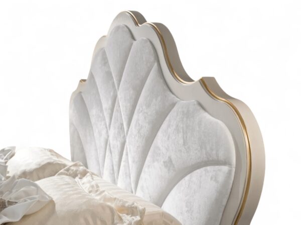 Regal bed with tufted ivory headboard and golden detailing