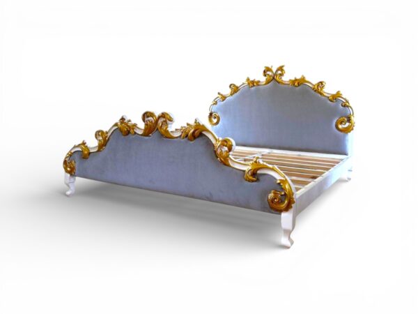 Gold-accented bed with tufted fabric and carved wooden frame