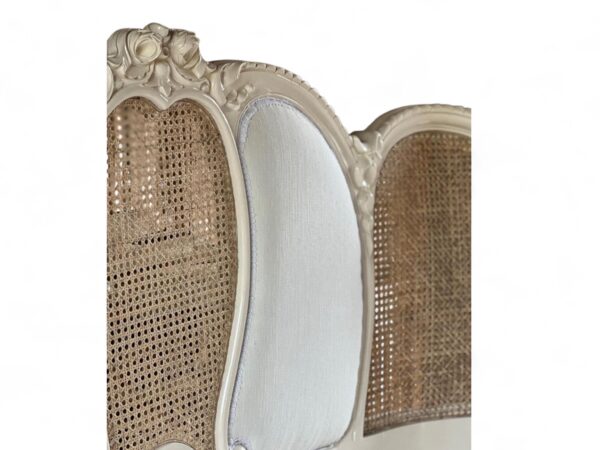 Vintage wooden bed with carved details and cane panel sides