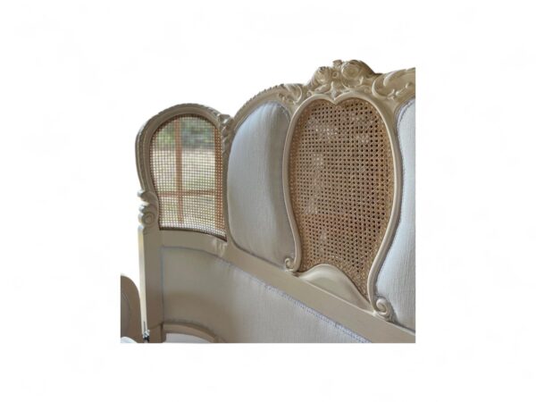 Vintage-inspired bed with French carving details and neutral upholstery
