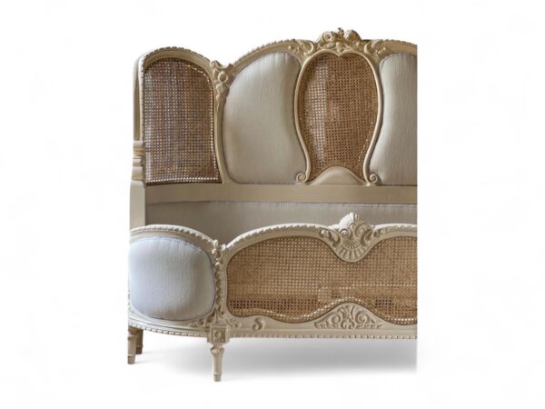 Elegant French bed with soft fabric upholstery and detailed wooden frame