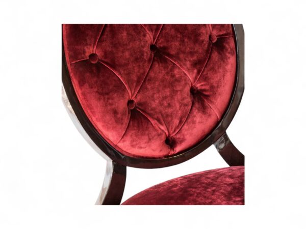 Red velvet dining chair with button-tufted back and wooden frame