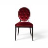 Red velvet dining chair with button-tufted back and wooden frame