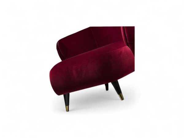 Tufted back velvet armchair with elegant black legs and brass tips
