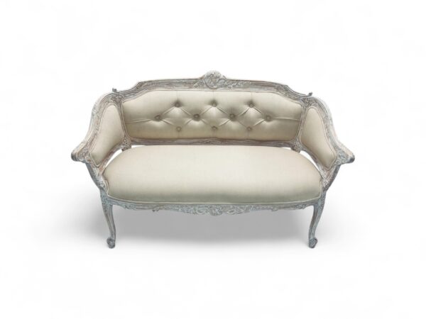 Elegant loveseat with soft neutral fabric and carved wooden frame