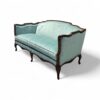Elegant French sofa with scalloped back and plush velvet seat