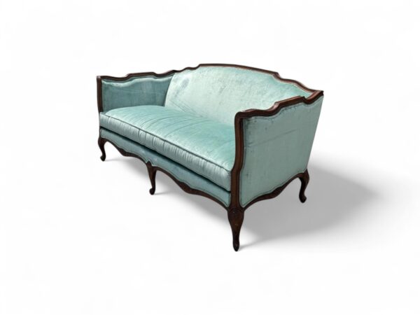 Elegant French sofa with scalloped back and plush velvet seat