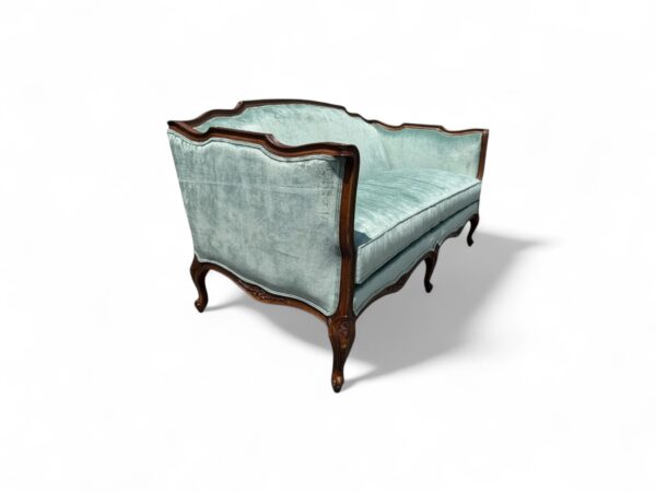 Side view of aqua blue French sofa with curved legs and arms