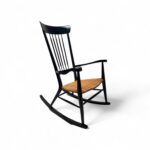 Sleek Spindle Rocker with handwoven cane seat and black frame