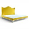 Sculptural yellow velvet bed with ivory piping and tapered legs