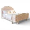 Ornate French-style bed with floral carvings and ivory accents