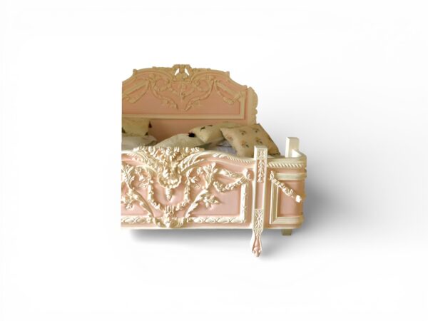 Ornate French-style bed with floral carvings and ivory accents