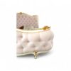 lassical style bed with tufted upholstery and gold detailing.