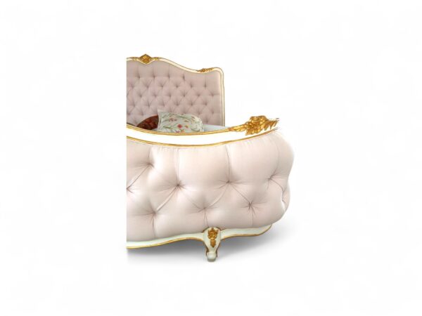 lassical style bed with tufted upholstery and gold detailing.