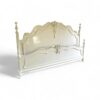 Antique-style French bed with soft white paint and carved detailing