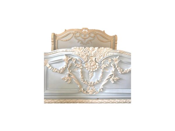 Pastel-colored carved wooden bed with detailed floral embellishments