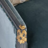 Luxurious teal velvet armchair with ornate golden armrest accents